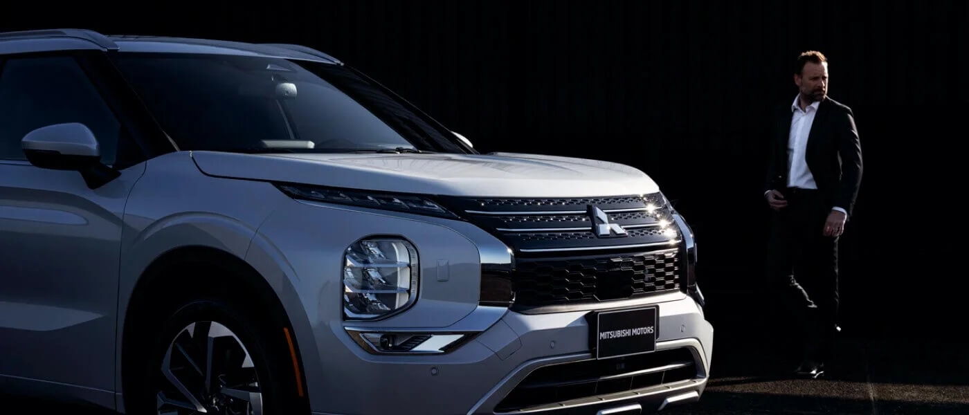 Un homme se dirigeant vers le Mitsubishi Outlander 2025.
