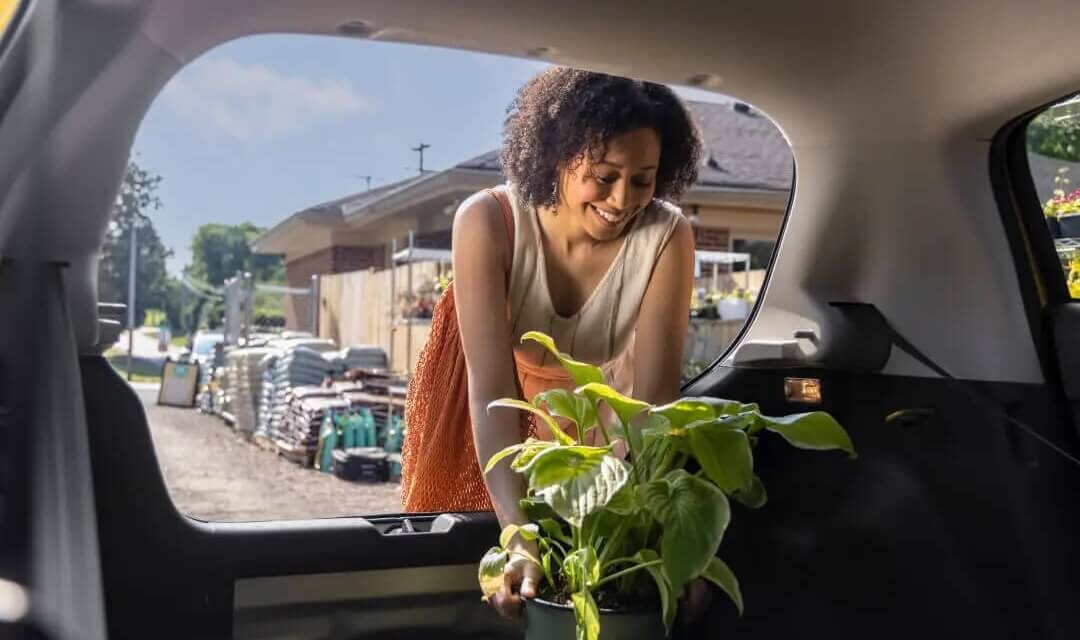 Femme chargeant le coffre généreux de 484 L de la Mitsubishi Mirage 2024.