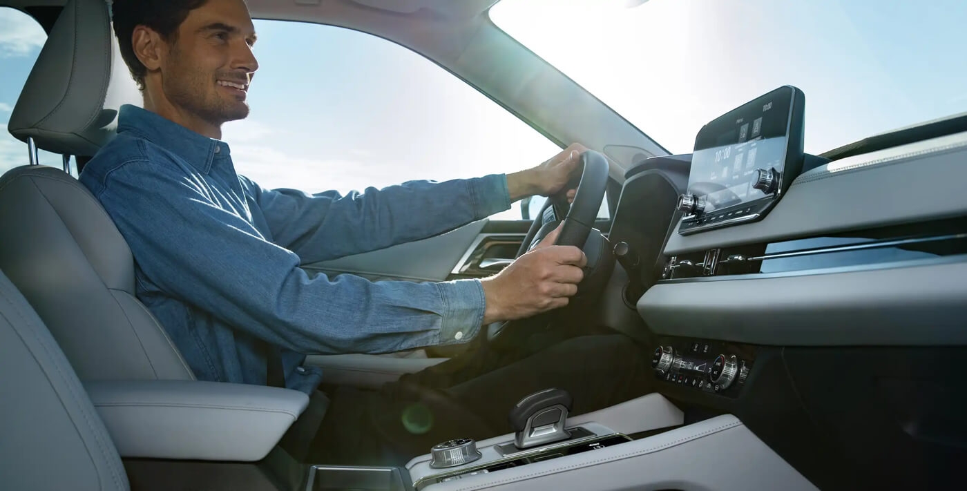 Les technologies abondent à bord du Mitsubishi hybride rechargeable avec un homme au volant du véhicule.
